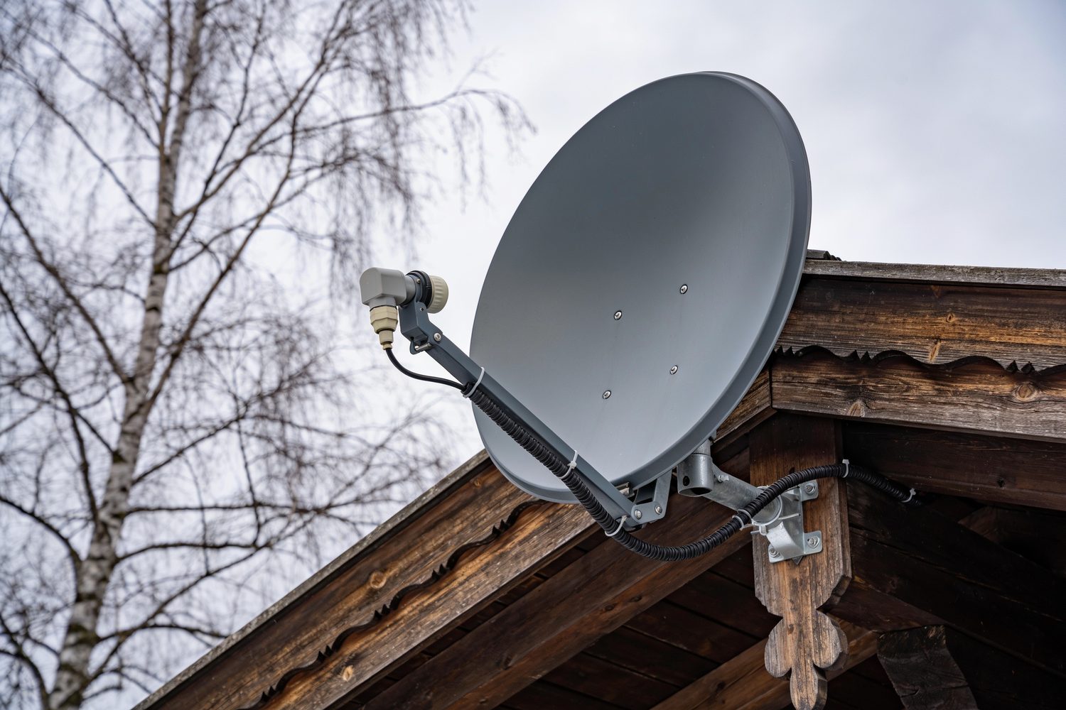 Satellitenschüssel am Giebel eines Holzhauses